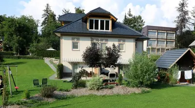 a house with a blue roof and a yard at Viktoria Apartments in Bled