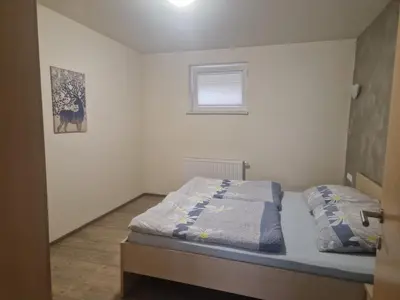 a small bedroom with a bed with a window at Viktoria Apartments in Bled