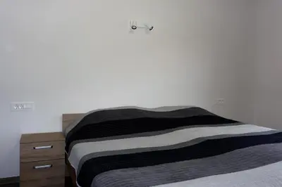 a bed with a black and white blanket and a dresser at Viktoria Apartments in Bled