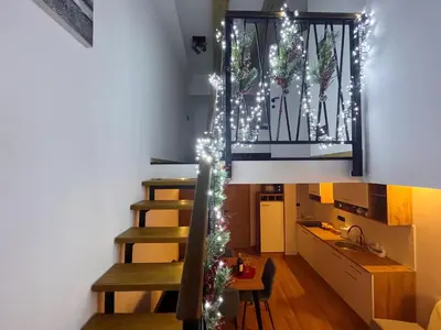 a kitchen with a staircase with christmas lights at Apartman LA CASA 77B in Ljubljana