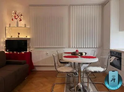 a living room with a table with chairs and a couch at Apartman LA CASA 77A in Ljubljana