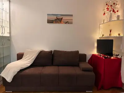 a living room with a brown couch and a table at Apartman LA CASA 77A in Ljubljana