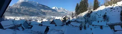 a village covered in snow with mountains in the background at Apartment Leposa in Kranjska Gora