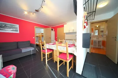 a kitchen and living room with a table and a couch at Apartment Leposa in Kranjska Gora