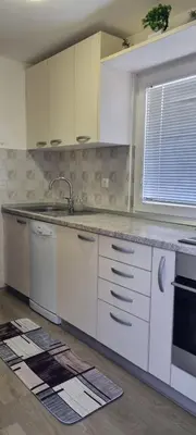 a kitchen with white cabinets and a sink and a window at Time4you in Čatež ob Savi