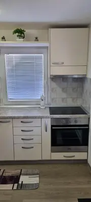 a kitchen with white cabinets and a black oven at Time4you in Čatež ob Savi