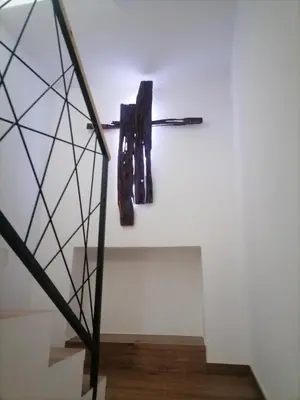 a staircase with two coats hanging on a wall at Lukova hiša- Luka's house in Vipava