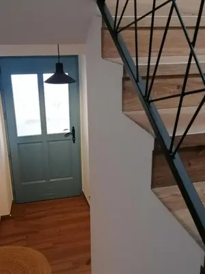 a hallway with a blue door and a staircase at Lukova hiša- Luka's house in Vipava