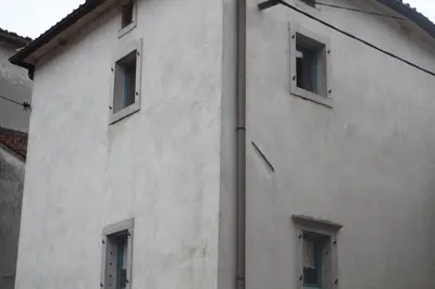 a white building with windows on the side of it at Lukova hiša- Luka's house in Vipava