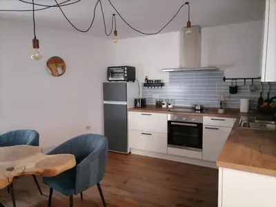 a kitchen with white cabinets and a table with chairs at Lukova hiša- Luka's house in Vipava