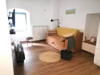 a living room with a couch and a wooden floor at Lukova hiša- Luka's house in Vipava