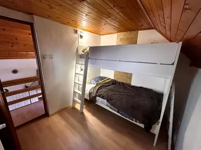 a bunk bed in a small room with a ladder at Apartma Bine in Cerkno