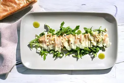 a white plate with a piece of fish with greens at Gostišče Barbara in Idrija