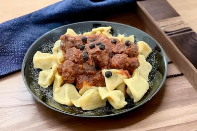 a plate of meatballs and pasta on a table at Gostišče Barbara in Idrija