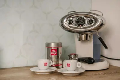 a coffee maker and two cups on a counter at Apartma Dreamscape in Radovljica