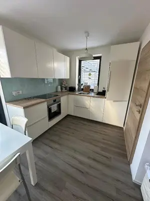 a kitchen with white cabinets and a window at Apartma Dreamscape in Radovljica