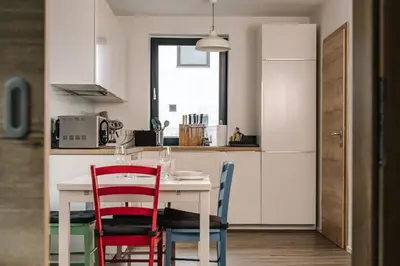 a kitchen with a table with two chairs and a kitchen with white cabinets at Apartma Dreamscape in Radovljica