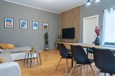 a living room with a table and chairs and a couch at Old Town's Legend: City center condo with balcony in Maribor