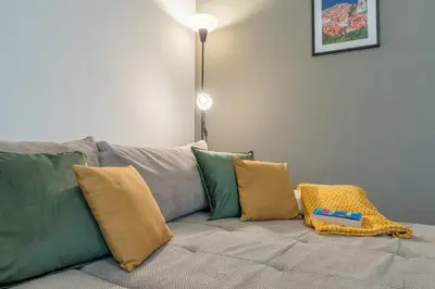 a couch with pillows and a toy train on it at Old Town's Legend: City center condo with balcony in Maribor