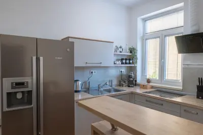 a kitchen with a stainless steel refrigerator and a sink at Old Town's Legend: City center condo with balcony in Maribor