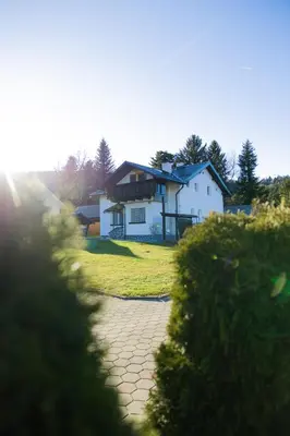 a white house with a pathway in front of it at Apartma Ella in Lovrenc na Pohorju