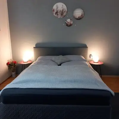 a bedroom with a blue bed with two side tables at Apartma Ella in Lovrenc na Pohorju