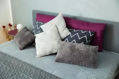 a bed with many pillows on top of it at Apartma Ella in Lovrenc na Pohorju