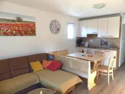 a living room with a couch and a table and a kitchen at Happy nes.t in Bovec