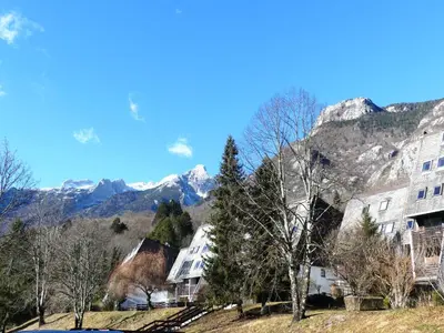a village in the mountains with mountains in the background at Happy nes.t in Bovec