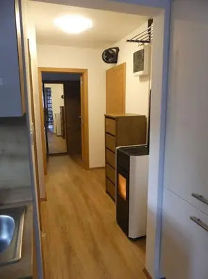 a room with a kitchen with a dresser and a hallway at Happy nes.t in Bovec