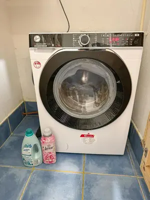 a washing machine is sitting on a tile floor at The North Apartment in Ljubljana