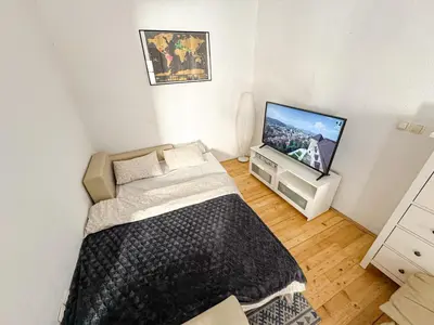 a small bedroom with a bed and a tv at The North Apartment in Ljubljana