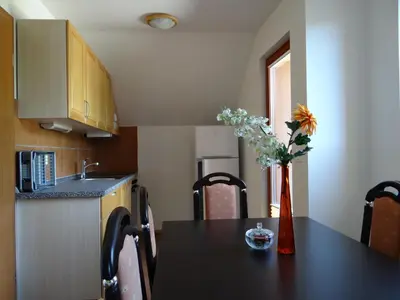 a kitchen with a table with a vase of flowers on it at Apartments Trebušak in Laze v Tuhinju