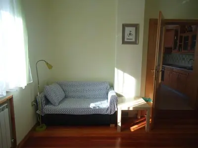 a blue couch in a room with a window at Apartment Šavli in Kobarid