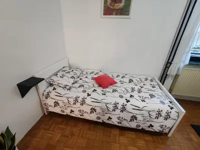 a bed in a room with a red pillow on it at Apartment Prešeren in Smarjeske Toplice