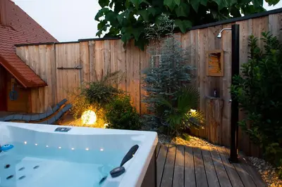 a bath tub in a backyard with a wooden fence at HIŠA ROSA in Veržej