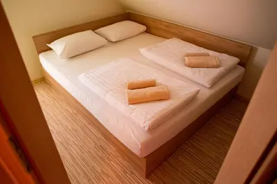 a small bed with two pillows on it at HIŠA ROSA in Veržej
