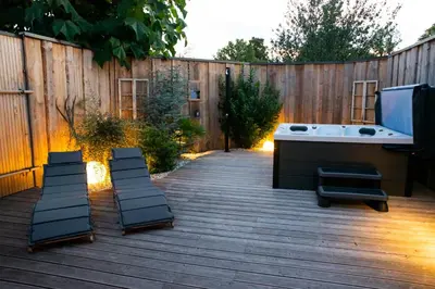 a backyard with a tub and a wooden fence at HIŠA ROSA in Veržej