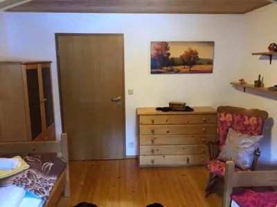 a bedroom with a bed and a dresser and a door at Apartma ČVRSTA TROJKA in Jesenice