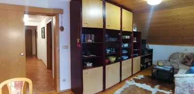 a living room with wooden cabinets and a couch at Apartma ČVRSTA TROJKA in Jesenice