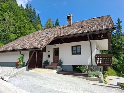 a white house with a brown roof at Apartma ČVRSTA TROJKA in Jesenice