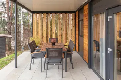 a table and chairs on a patio with a fence at Apartma LeMa in Velike Lašče
