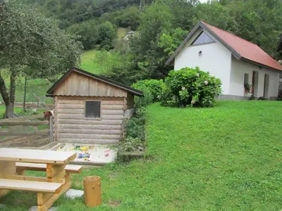 a small wooden house with a picnic table in a yard at Apartment Sever in Idrija