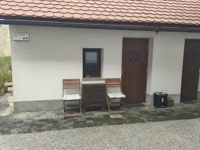 two chairs sitting on the outside of a house at Apartment Sever in Idrija