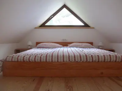 a bedroom with a large bed with a window at Apartment Sever in Idrija