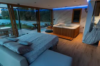 a bedroom with a large bed and a tub at Luxury Resort Potatoland in Šenčur
