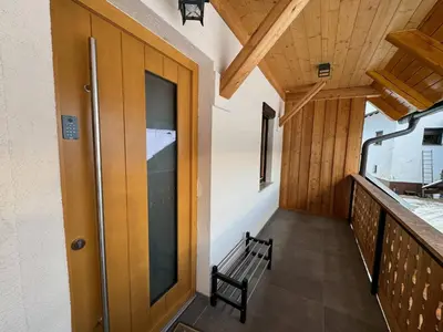 a hallway with a wooden door and a bench at Gloria Holiday - Kranjska Gora Apartments in Kranjska Gora