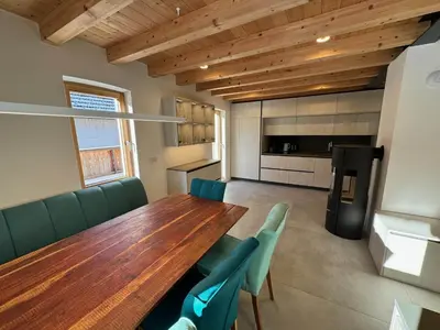 a dining room with a wooden table and green chairs at Gloria Holiday - Kranjska Gora Apartments in Kranjska Gora