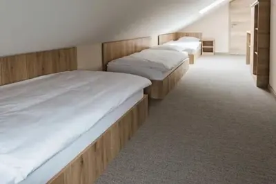 a row of three beds in a room at EnDi Rooms in Ljubljana