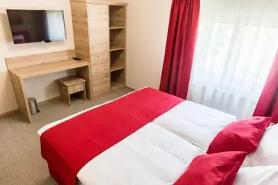 a bedroom with a red and white bed and a television at EnDi Rooms in Ljubljana